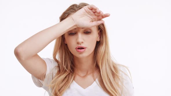 Young Beautiful Caucasian Blonde Girl Waving Hands From Imaginary Heat on White Background alt