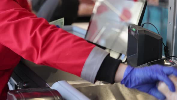 the Seller Scans the Goods at the Checkout in the Supermarket alt