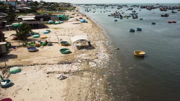 Aerial, traditional round coracle fishing boats floating on coast in Vietnam alt
