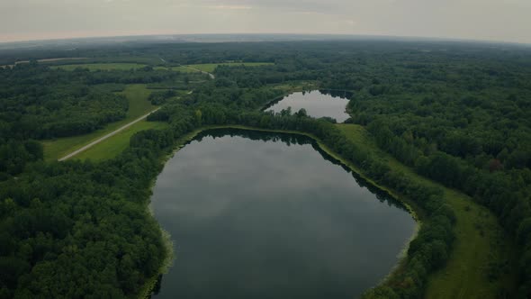 Aerial View of Lakes with Growing Forest Reflection of Sky and Clouds in the Water