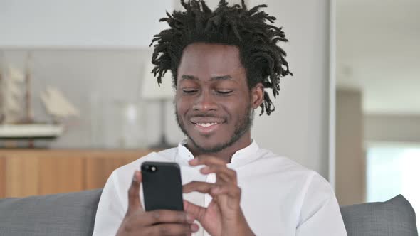 Portrait of African Man Using Smartphone  alt