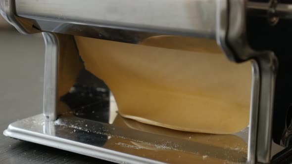 Pasta machine processed dough 4K 2160p 30fps UltraHD footage - Close-up of manually shaped lasagna s alt