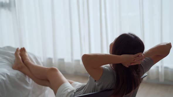 Young Asian woman relaxing in the bedroom in the morning