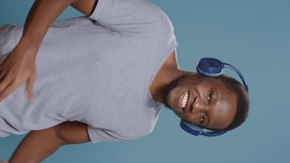 Vertical Video Modern Person Enjoying Online Music on Headset and Dancing alt