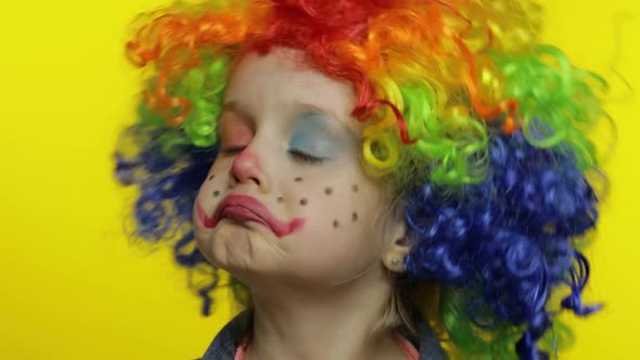 Little Child Girl Clown in Colorful Wig Tells Something Interesting. Having Fun, Smiling. Halloween alt
