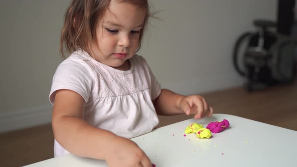 Caucasian Toddler Girl Playing Modeling Play Dough at Home with Mother. Homeschooling Concept alt