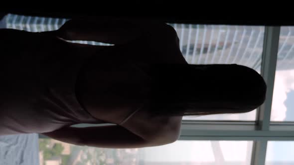 Woman Walks to the Window in the Skyscraper with Her Back to the Camera alt