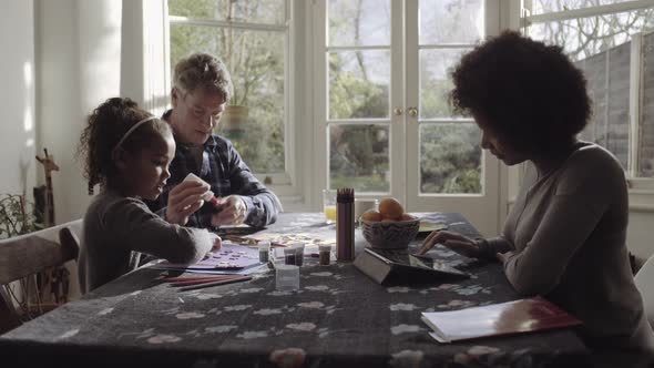 Parents with daughter drawing in living room