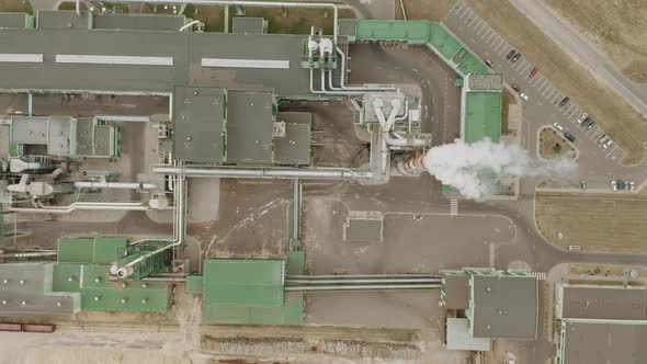 Aerial Top Down View of Woodworking Plant Near Pine Forest, High Chimney Smoke, Large Stocks of Wood alt