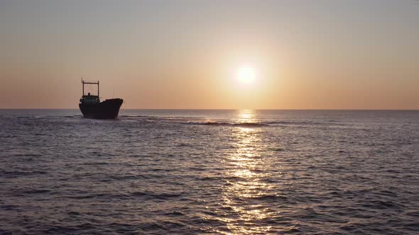 Aerial Of Rusty Shipwreck In The Sea With Crashing Waves During Sunset 1 alt
