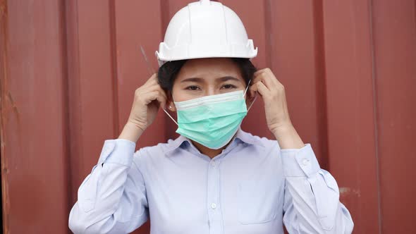 Female engineer wearing protective mask looking at camera