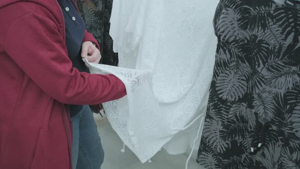 Pregnant Woman in the Store Chooses a Loose White Lace and Transparent Dress
