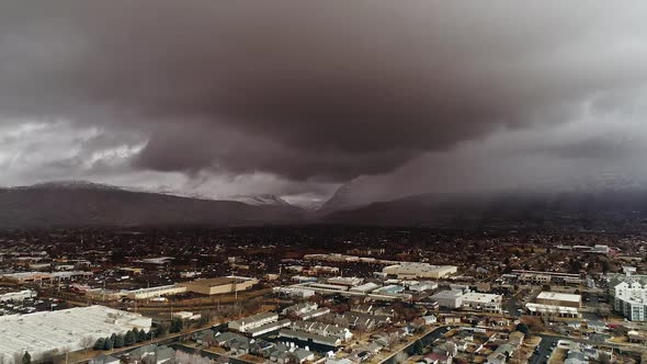 Flying backward over town with gloomy storm moving over the landscape alt