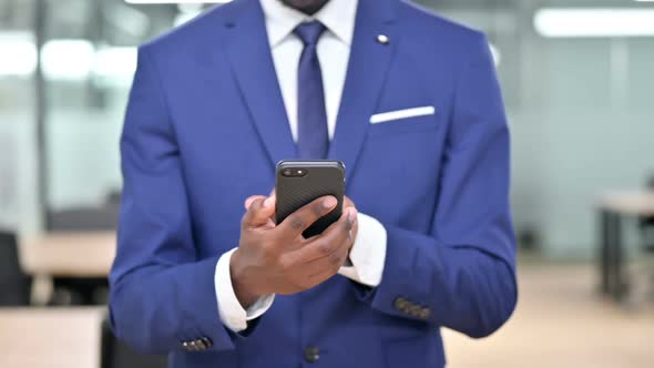 African Businessman Using Smartphone at Work alt