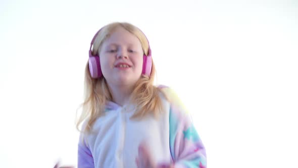 Beautiful Blonde Girl Listens To Music with Headphones and Dancing