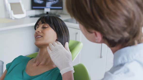 Caucasian female dental nurse talking with female patient at modern dental clinic alt