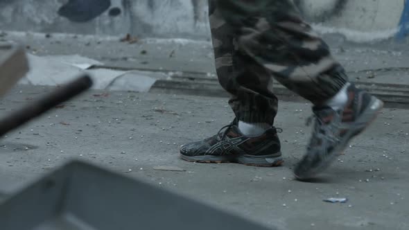 The feet of a personal trainer man before doing a workout inside an abandoned building. alt