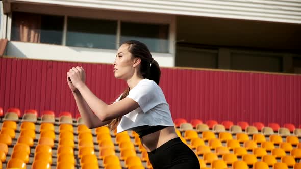 Young Slim Asian Brunette Female in Sportswear Does Sports Exercises at Stadium