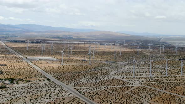 Aerial View of Huge Array of Gigantic Wind Turbines Spreading Over the Desert in Palm Springs. alt