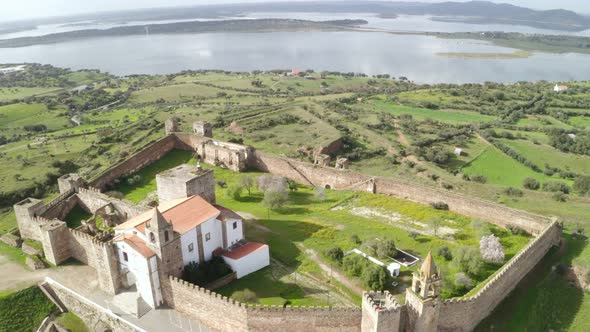 Aerial drone view of Monsaraz in Alentejo, Portugal at sunset with alqueva dam lake on the backgroun alt