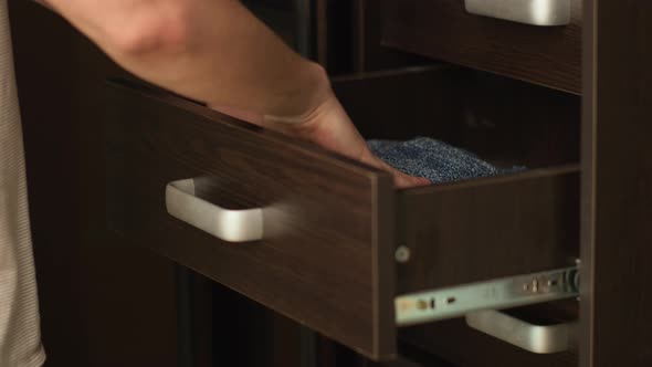 A Man Puts Things in Order in a Closet Puts Things on a Shelf Closeup alt