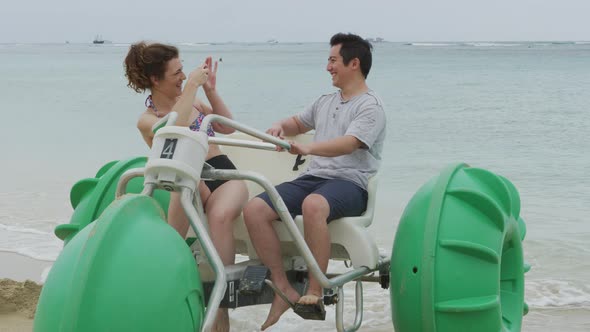 Couple taking cell phone photos on water tricycle in Hawaii