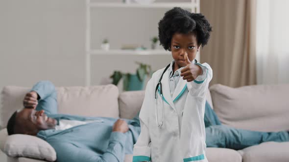 Little African American Daughter Playing with Dad Father Patient Lying on Couch Kid Girl Pretending alt