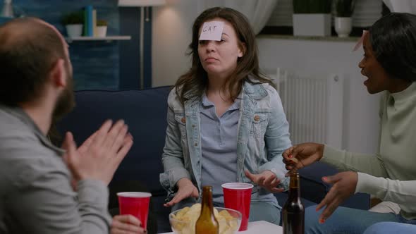 Multiracial Group of People Laughing While Playing Guess Who Game with Sticky Notes alt