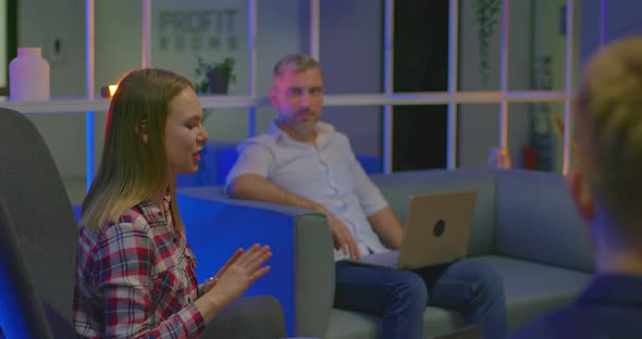 Young Female Freelancer is Talking to Partners She is Smiling and Gesticulating