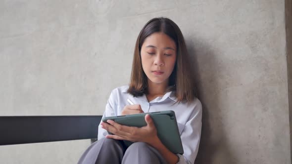 Female designer working on digital tablet download application. alt