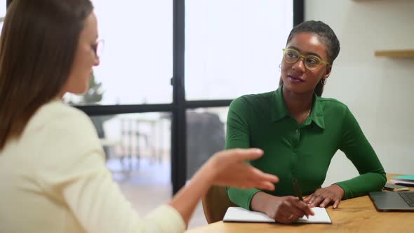 Diverse Female Partners Brainstorming in Meeting Room Multiracial Woman Takes Notes