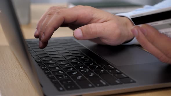 Close Up Hands Man Pressed Credit Card Code to Pay Online Shopping Via Laptop alt