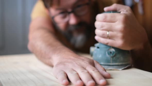 Carpenter touching wooden surface after grinding
