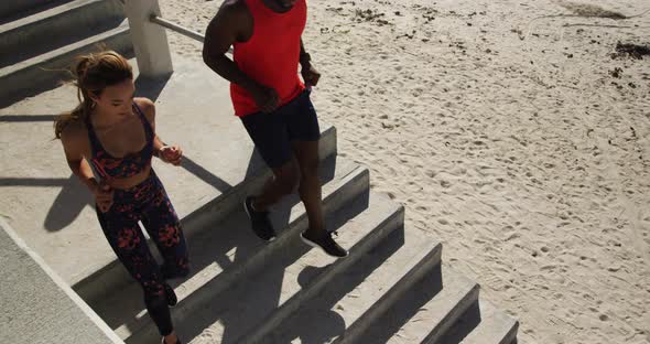 Couple jogging on a stairs at beach 4k