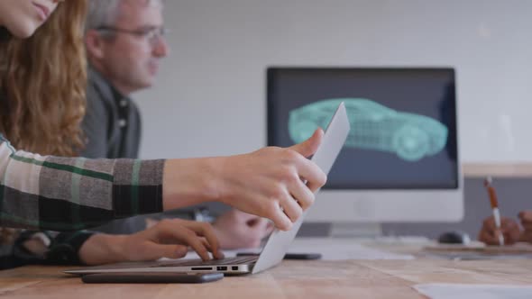 Two women and a man working in a creative office alt