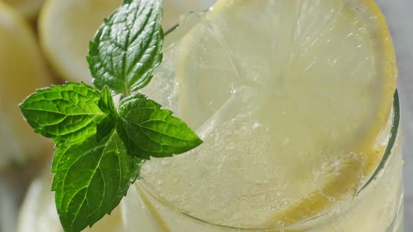 Soda Is Poured Into A Glass With An Iced Lemon Drink And Fresh Mint.