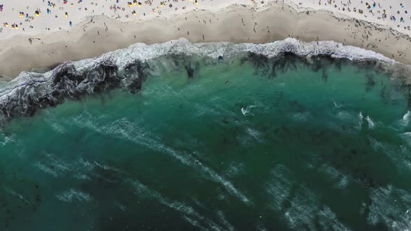 Top down view of a kite surfer riding some waves at Camps Bay beach