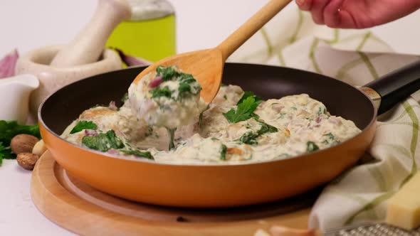 Delicious Small Meatballs with Spinach in a Creamy Sauce in the Frying Pan alt