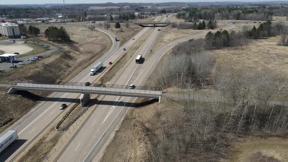 Aerial view of freeway crossroads with pedestrian bridge and highway bridge on bright autumn day.