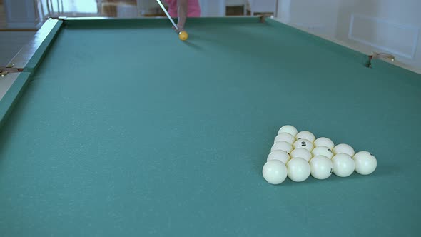Man Playing Billiards Breaking a Pyramid of Balls alt