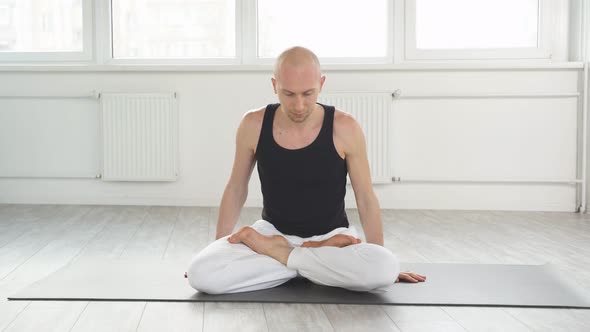 Professional Yoga Man Sits on Mat on Floor Training Correct Yoga Breathing