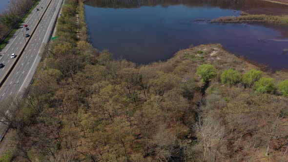 An aerial view of a reflective lake during the day. The drone camera dolly out over the lake with dr alt