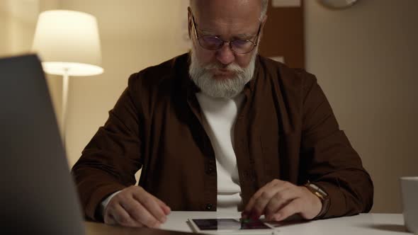 man works at night by the light of a lamp