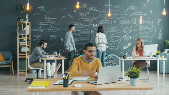 Time Lapse of African American Man Working in Open Space Office Writing Using Laptop alt