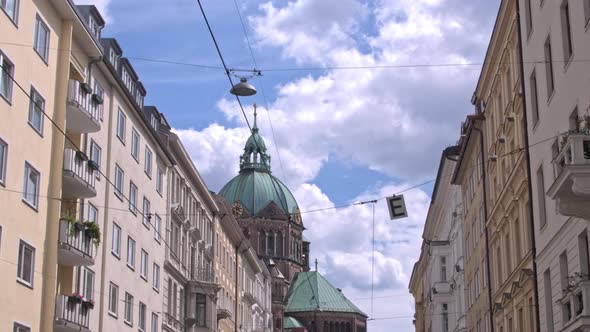 Residential Buildings in Munich on the Background of the Majestic Church of St. Luke. alt