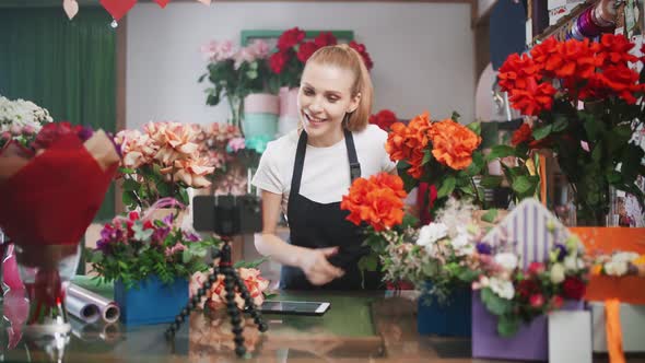 Female Florist Discusses the Order By Talking on Video Call Using a Smartphone and Screen Tablet in alt