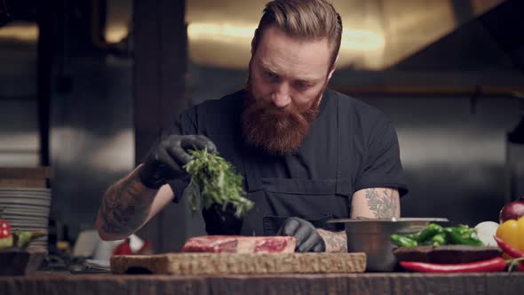 Chef cook preparing raw steak.