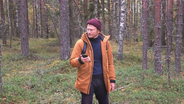 Caucasian Man Using Smartphone to Find His Location in the Forest