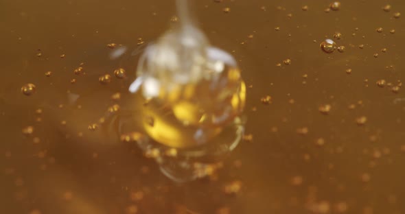 Macro shot of honey. More honey getting poured in creating small air bubbles. alt