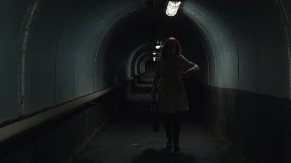 Redhead woman with mobile phone going through the tunnel